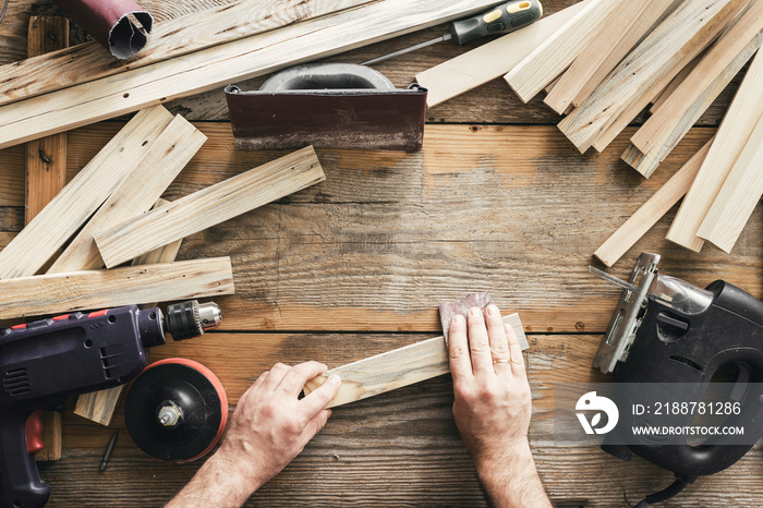 Carpenter working carpentry workshop Man sanding manually plank top view