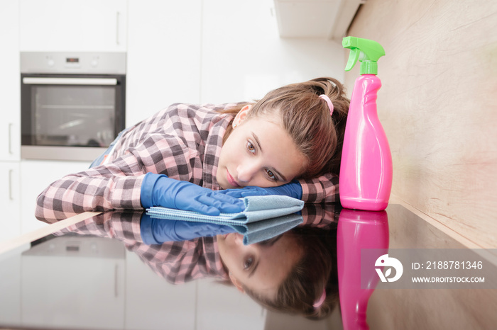 Tired frustrated and exhausted cleaning woman .Cleaning the kitchen in protective gloves.