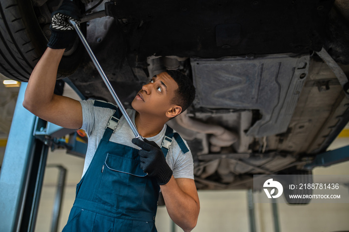 Auto mechanic in work gloves repairing the customer automobile