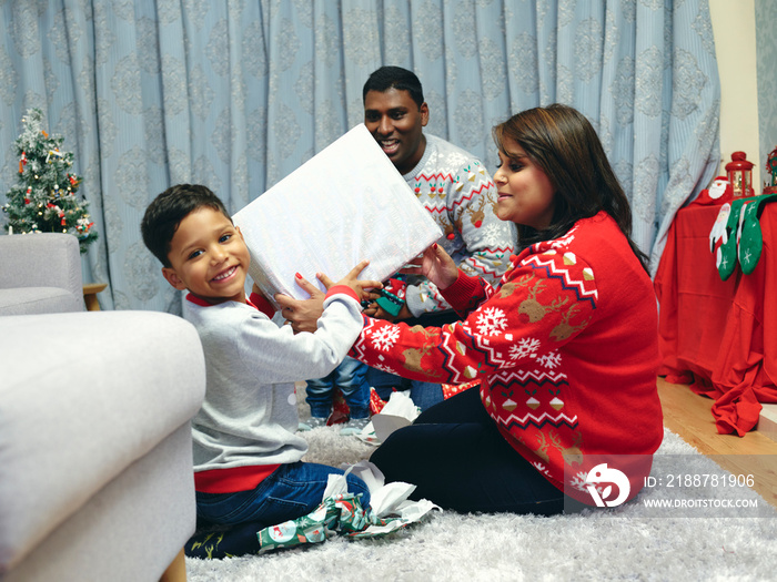 Family with sons opening Christmas presents