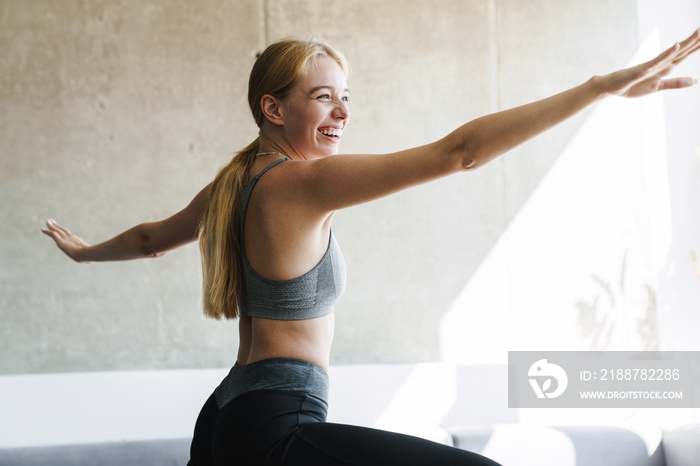 Photo of joyful woman smiling and doing exercise while working out