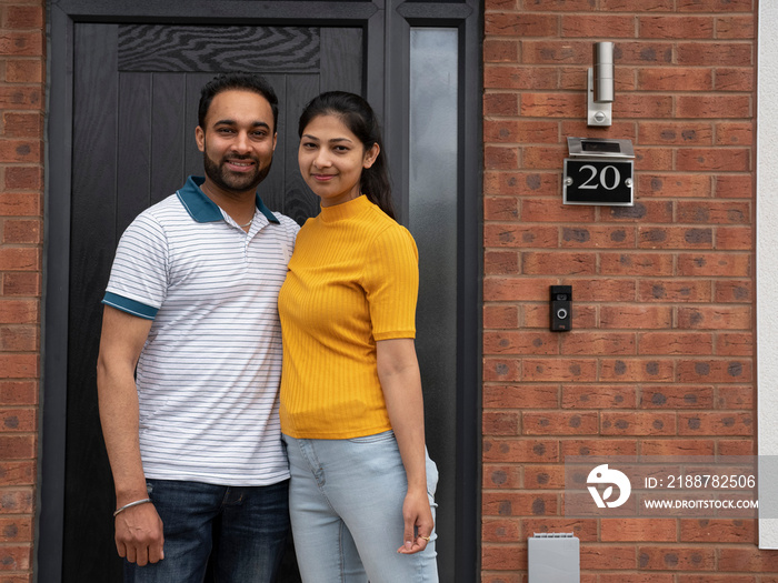 Portrait of couple standing on front porch