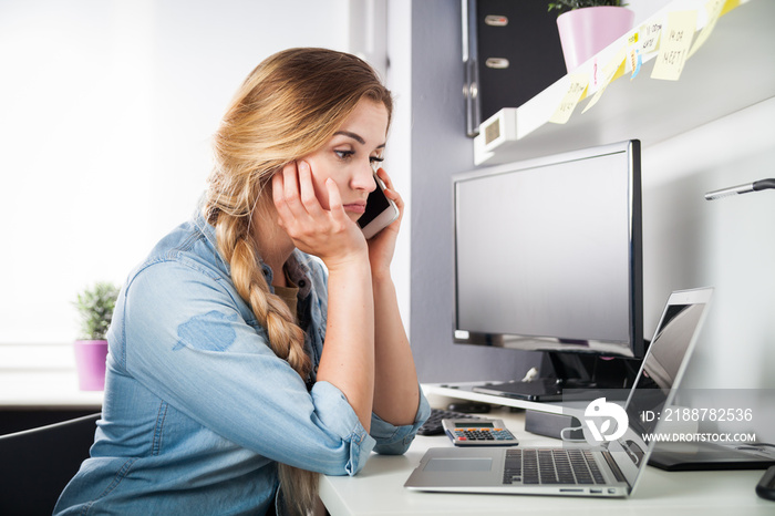 Stressed woman talking on phone at home office business problems concept