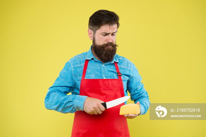 expertise cheese taste. ciet and nutrition. serious bearded man cut cheese with knife. cheesemaking concept. cheesemaker own business. hipster beard in chef apron. Dairy food shop. cheese festival