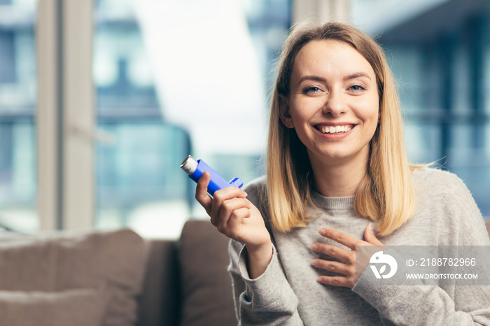 Beautiful girl smiling at camera while holding inhaler