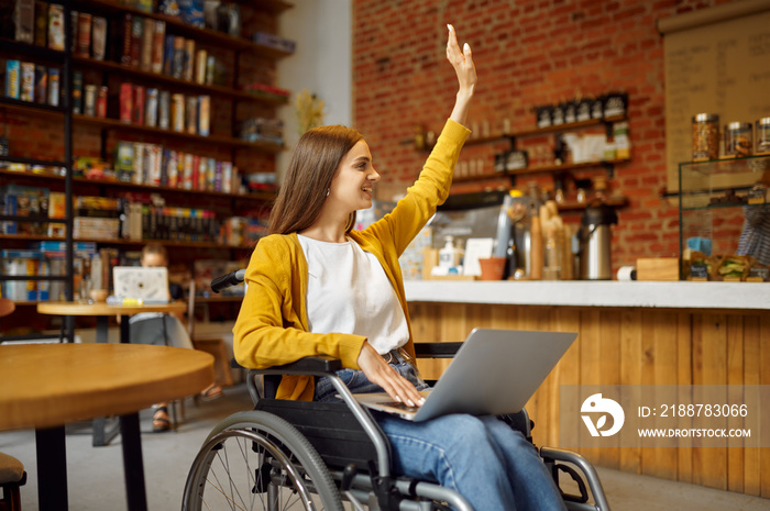 Disabled student in wheelchair with raised hand