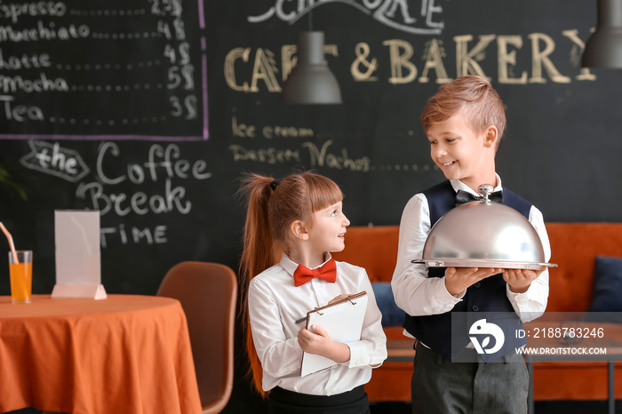 Cute little waiters in restaurant