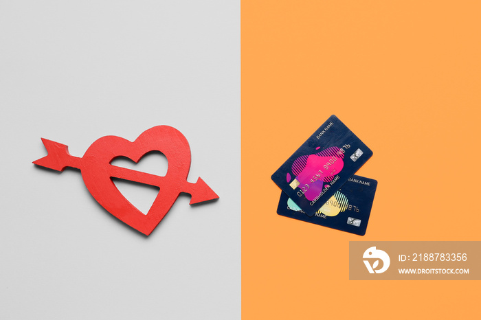 Credit cards and heart on color background. Concept of balance