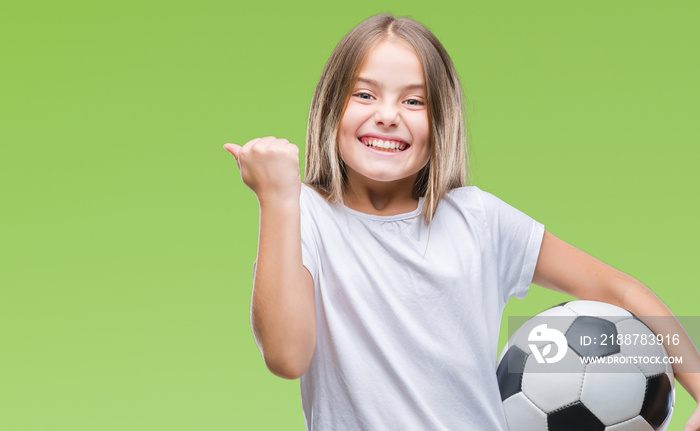 Young beautiful girl holding soccer football ball over isolated background screaming proud and celebrating victory and success very excited, cheering emotion