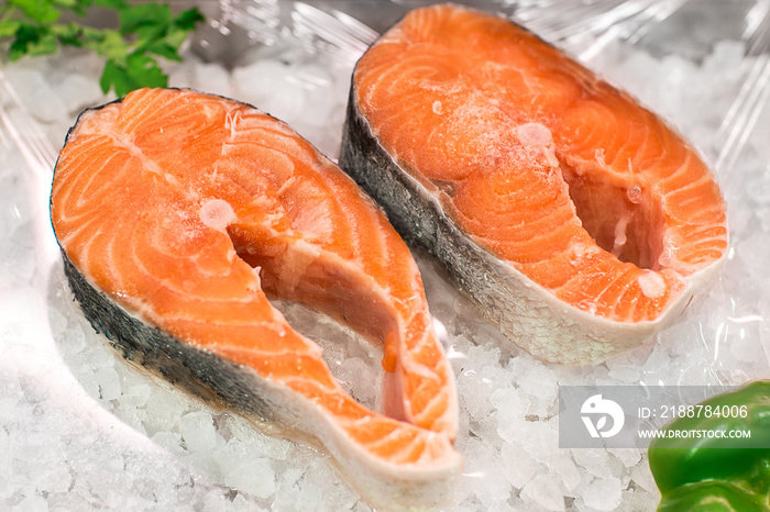 Salmon Red Fish Steak at the fish market. Raw fresh steaks of Salmon fish as background. Large Pile of salmon steak with ice. Big organic steaks of salmon lined up for sale.