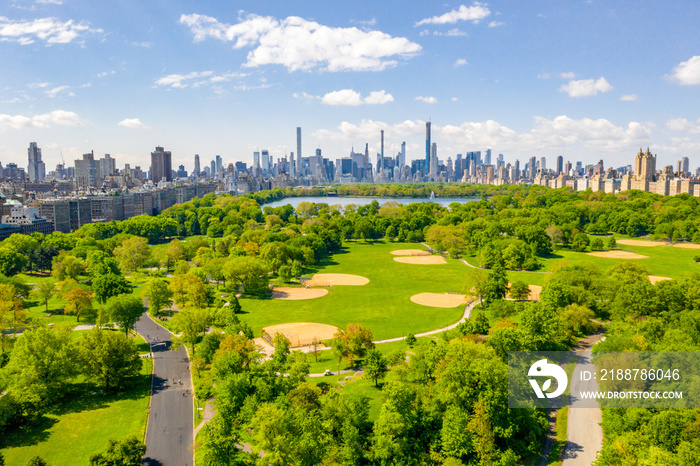 Aerial view of the Central park in New York with golf fields and tall skyscrapers surrounding the park.