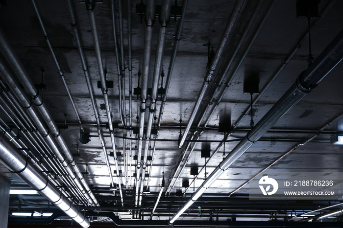 Sanitary system pipes and electrical cables installed under flat slab reinforced concrete structure in building.Ventilation pipes in Underground Parking