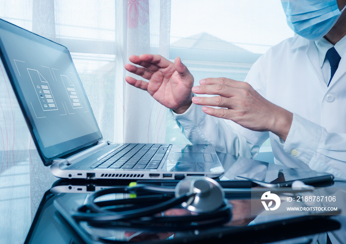 The doctor working on a laptop computer for health records in the medical office.The concept is checking and taking care of patients’ health online.