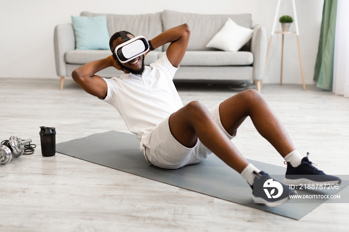 African Man Wearing VR Glasses Doing Abs Exercise At Home