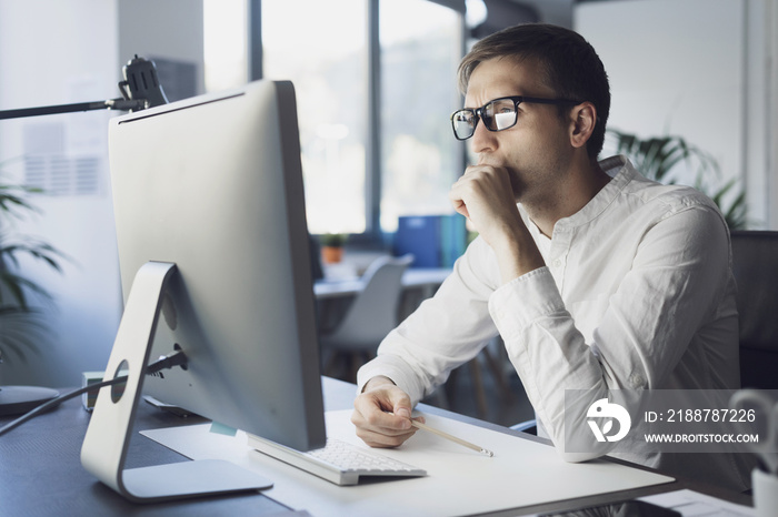 Businessman working with his computer and thinking