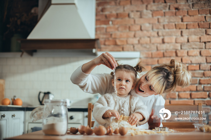 Mother and daughter baking cookies in their kitchen