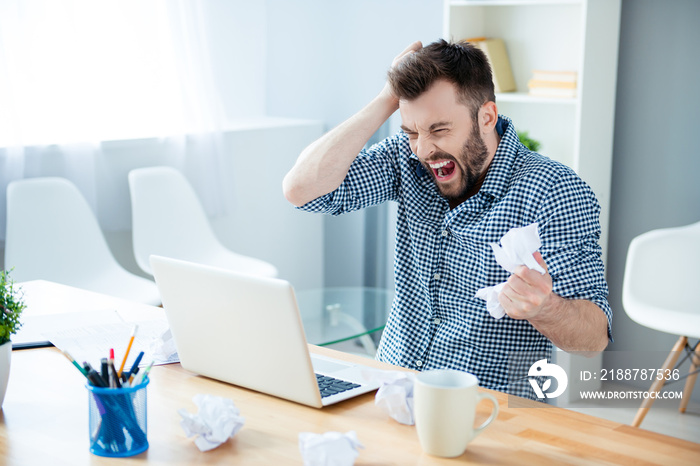 Angry crazy bearded businessman yelling and crumpling paper on h