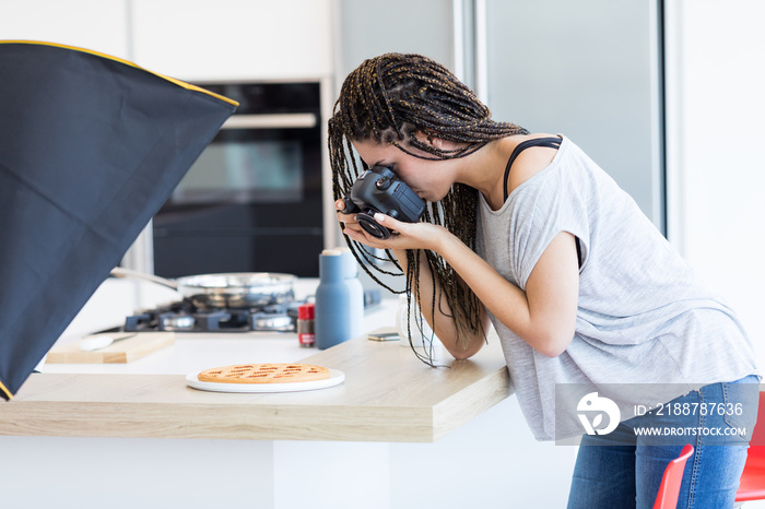 Girl taking photo of jam tart in studio