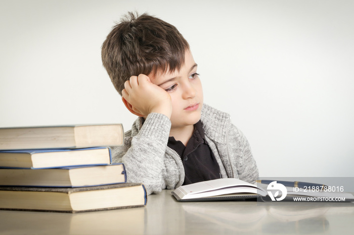 Studio portrait of young boy struggling with his homework - learning difficulties concept