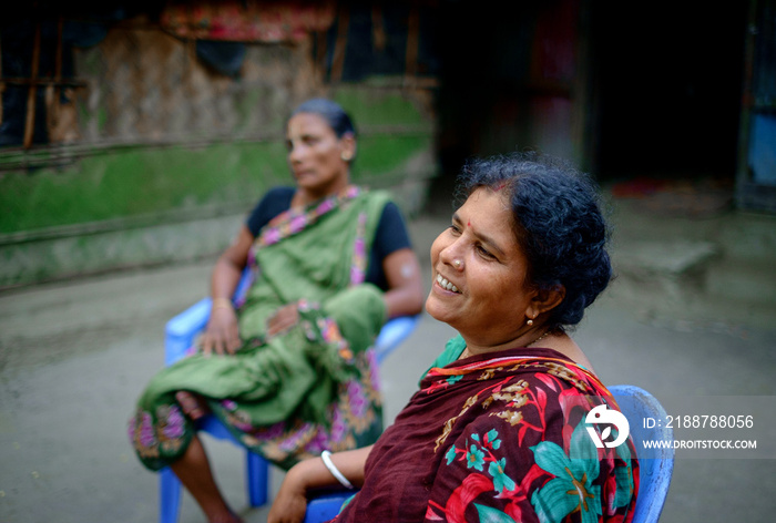 South asian village women gossiping with each other sitting outdoor in a leisure time