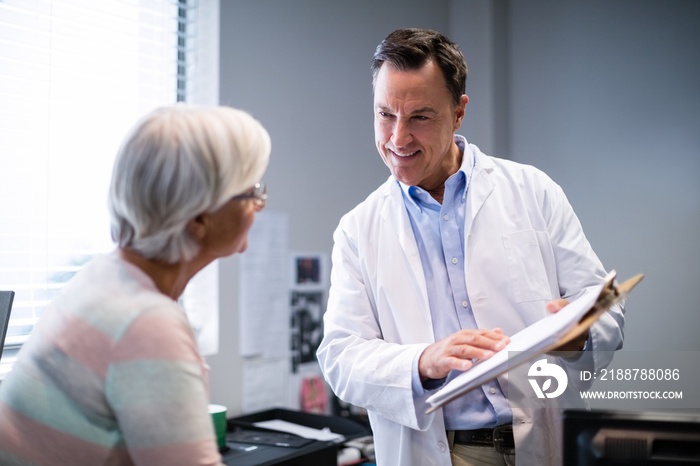 Doctor and senior patient discussing on clipboard