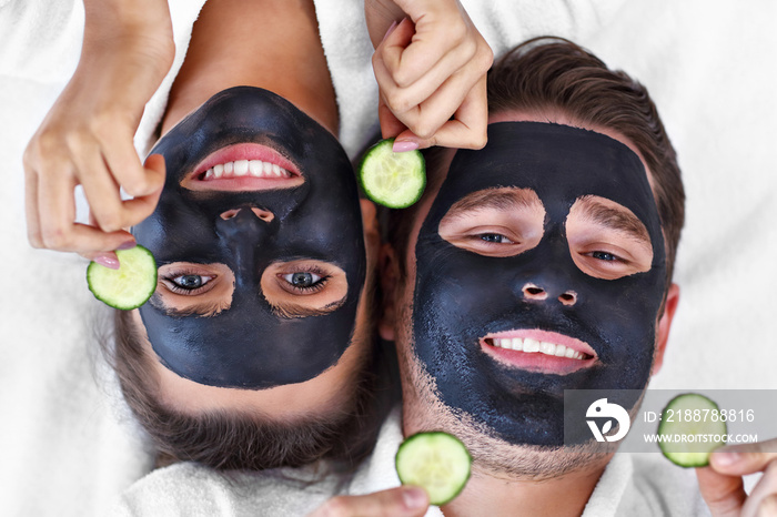 Happy couple having facial in spa salon