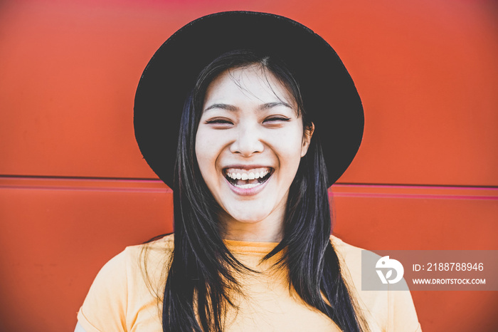 Portrait of happy asian girl smiling with coral background