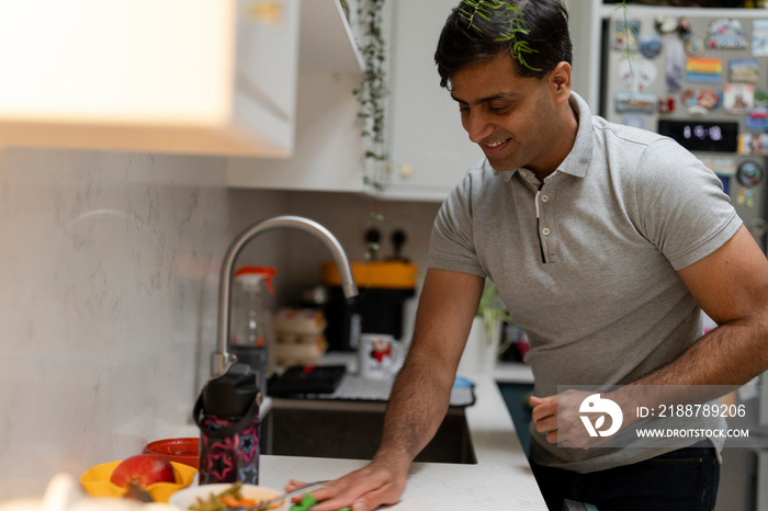 Man cleaning counter in kitchen