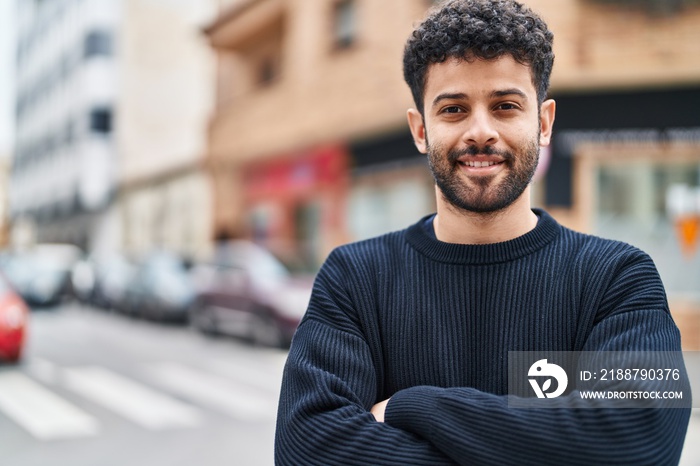 Young arab man smiling confident standing with arms crossed gesture at street