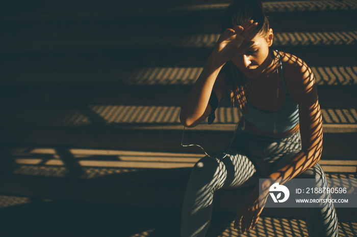 Young female runner resting on the stairs