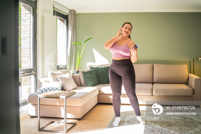 European woman dancing at home while feeling free and great emotions