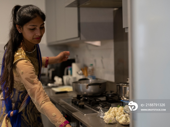 Young woman in traditional clothing cooking meal together