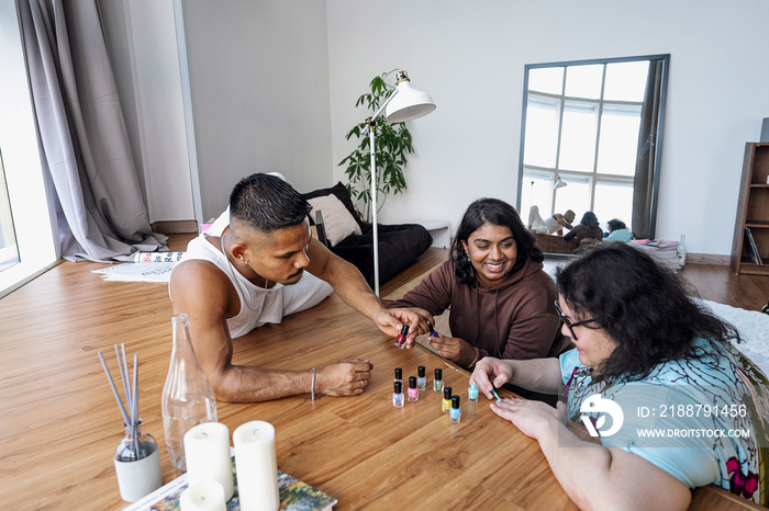 Three friends painting their nails together at home