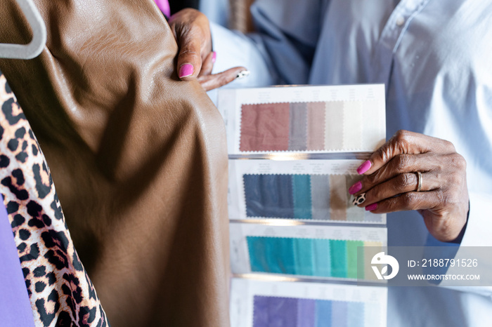 Close-up of fashion designer comparing color swatches with clothing