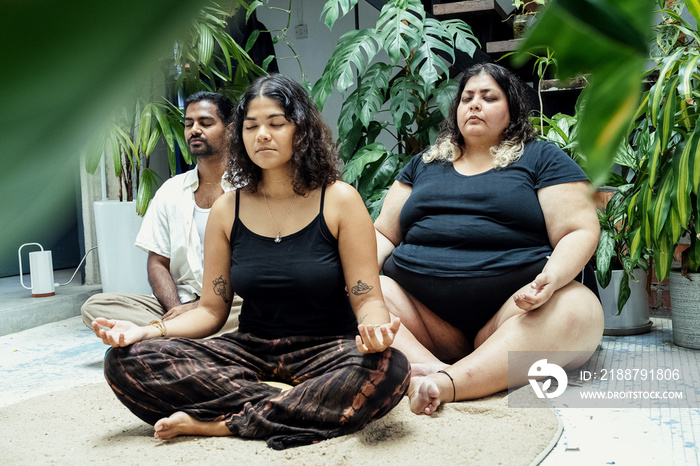 Friends meditating together at home