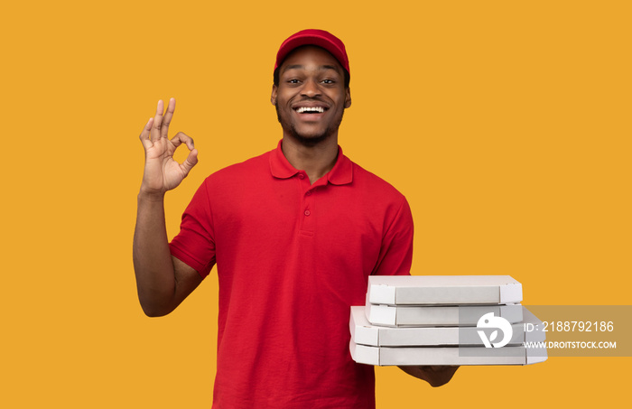 Black delivery man holding pizza boxes, showing okay gesture