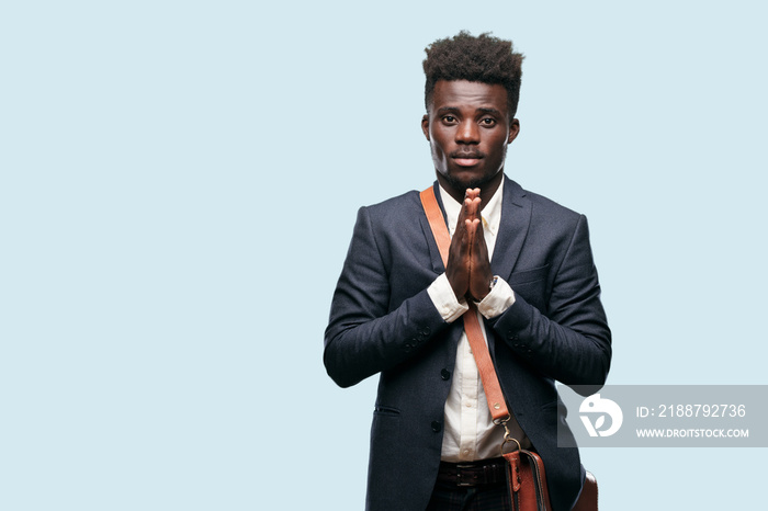 young black businessman praying in a saintly manner, begging  please  for a wish to happen.