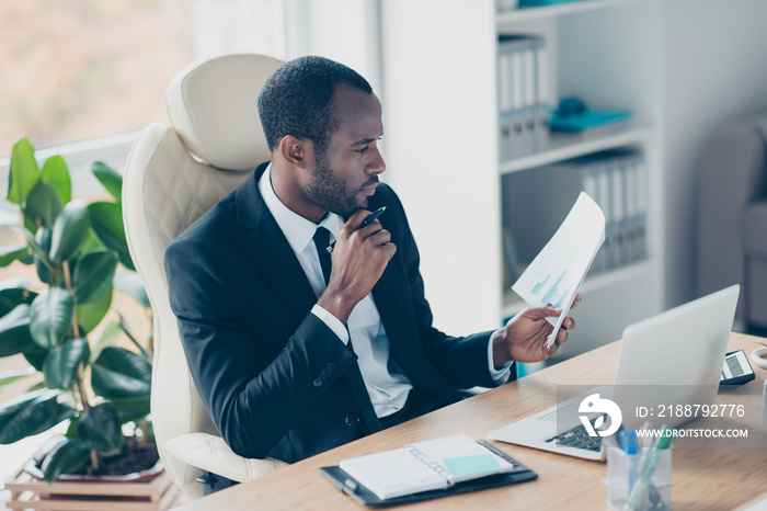 Hardworking economist sitting at desktop in work station, place, watching, checking, examine, looking at documents, report, holding hand on chin, ponder, minded, consider