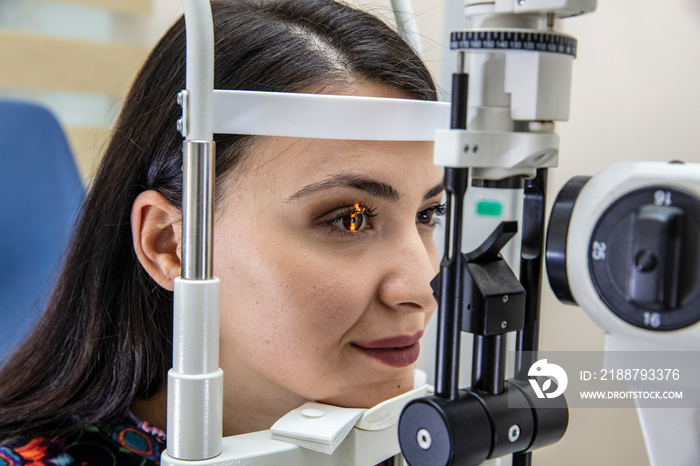 High technology concept health for eyes care - The optician ophthalmology doctor optometrist in the eyes clinic using a binocular slit-lamp to a young woman for an eye control.