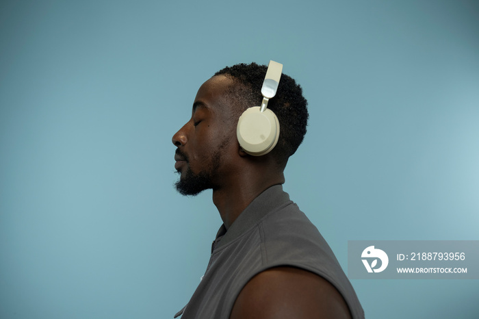 Profile of man wearing headphones and listening to music