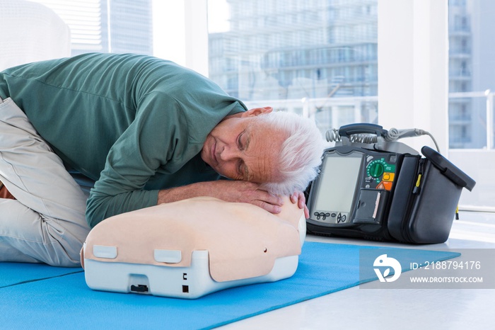 Paramedic practicing resuscitation on dummy