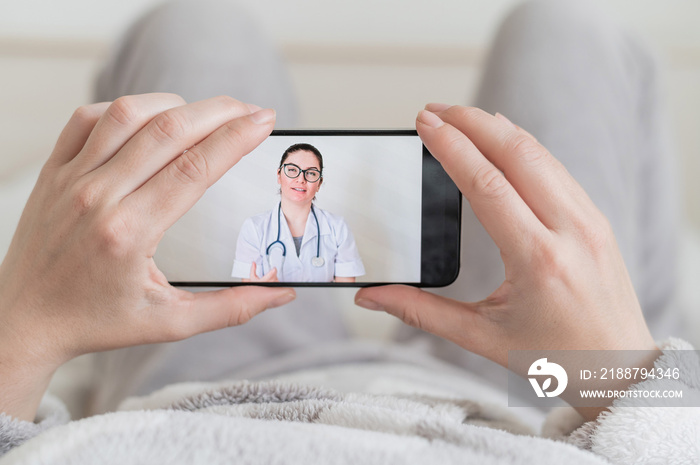 Close-up of female hands holding a phone with a doctor on the screen. Video call from the attending physician. Woman at an online appointment with a psychologist