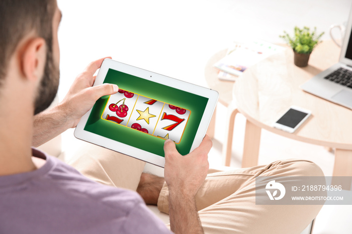 Young man searching information using tablet at home