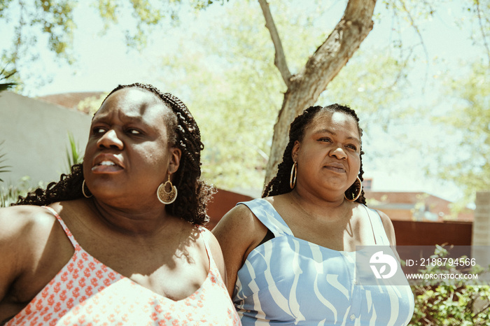 closeup of 2 plus size African American women looking away