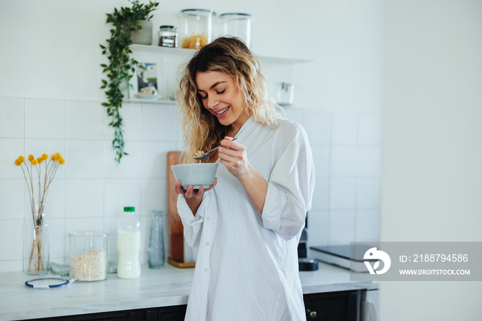 Woman at home eating a bowl of cereals for breakfast