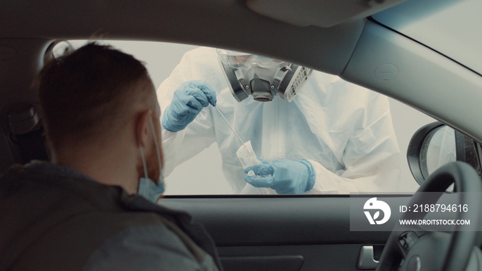 Patient is being tested in his vehicle on a drive-through coronavirus COVID-19 testing location. Pandemic, infection