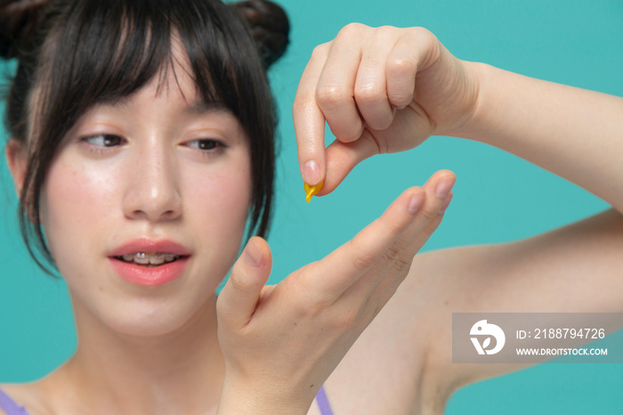 Close-up of girl dropping serum on hand