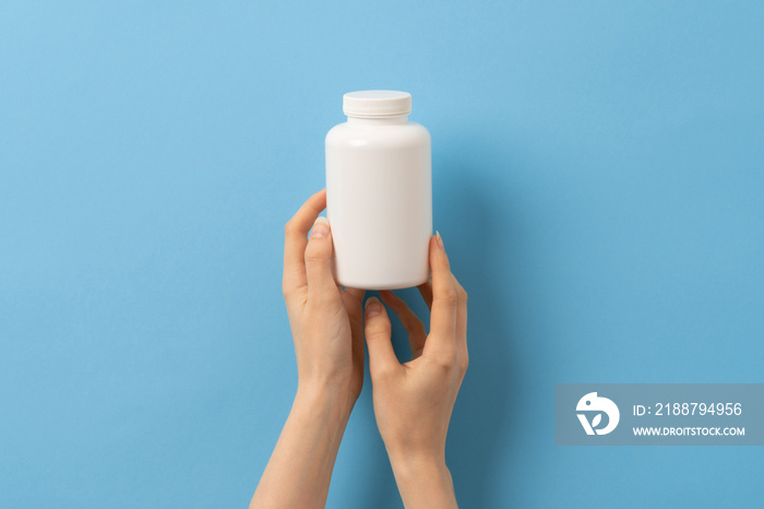 Female hand holding bottle of medication pills