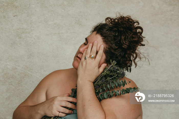 close up portrait of a plus size woman holding eucalyptus