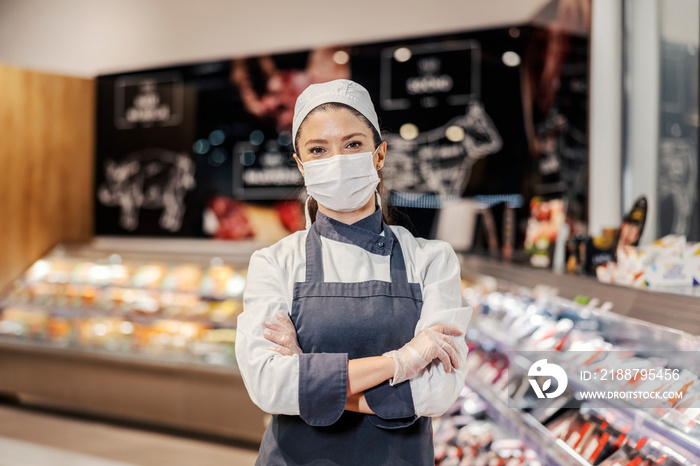 Portrait of a female butcher at supermarket during corona virus.